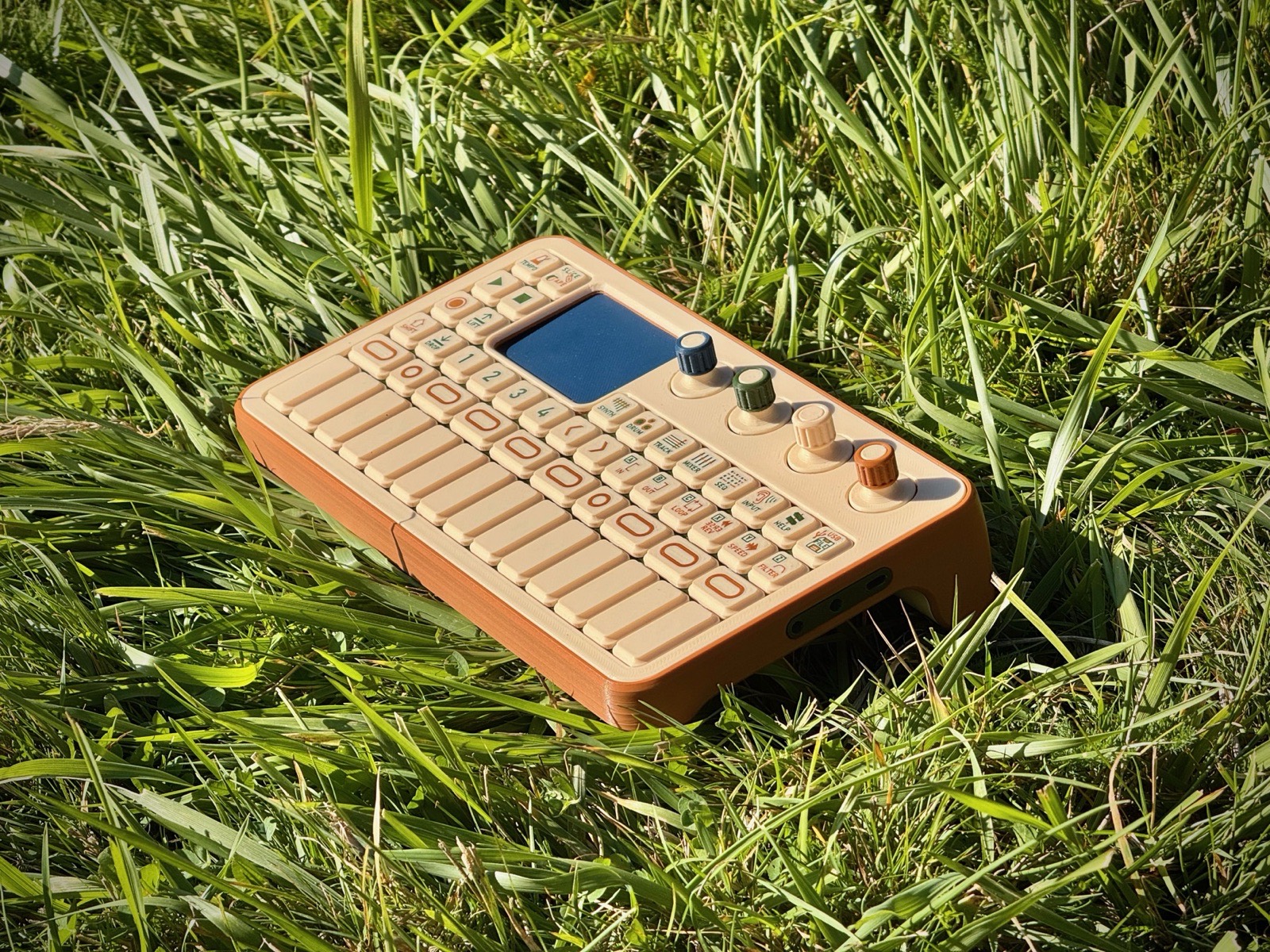 Look-alike model in grass, three-quarter view from the right, showing the audio jacks on the end