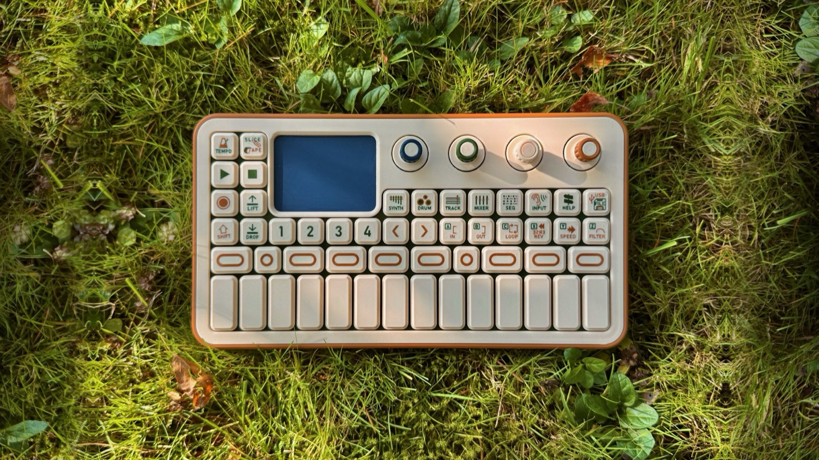 Top-down photo of the look-alike model: 52 keys on a grid, four knobs, a blank screen